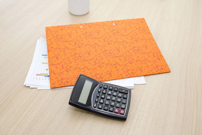 High angle view of calculator with documents on desk in office