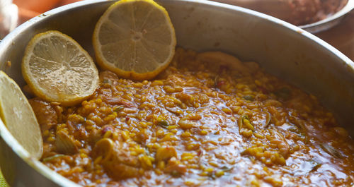 Seafood paella with lemon on kitchen table