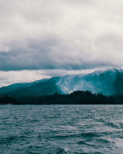 Scenic view of sea and mountains against sky