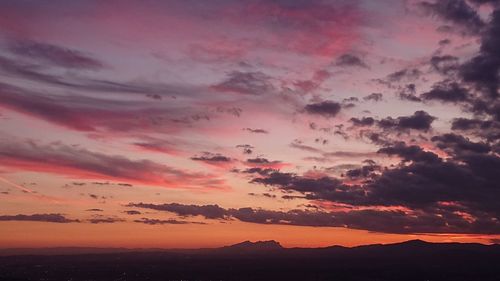 Scenic view of dramatic sky over silhouette landscape