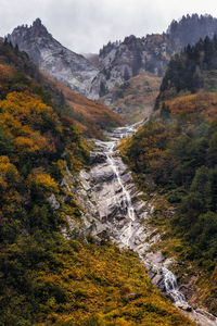 Scenic view of waterfall against sky during autumn