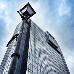 Low angle view of modern building against cloudy sky