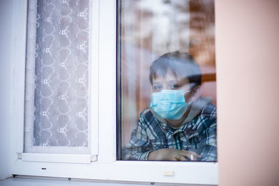 Portrait of man looking through window