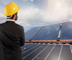 Low angle view of man working against sky