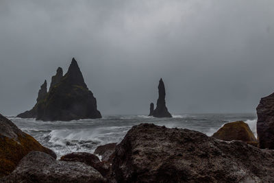 Rock formations by sea against sky