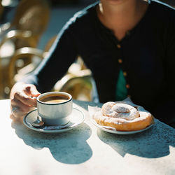 Close-up of person with coffee on table