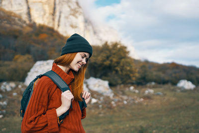 Woman wearing hat standing against sky during winter