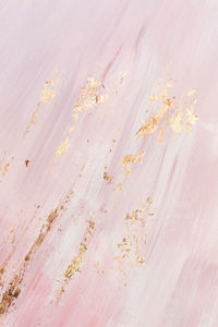 Delicate pink marble background with gold brushstrokes. place for your design.