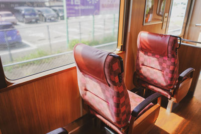 Empty chair by window in train