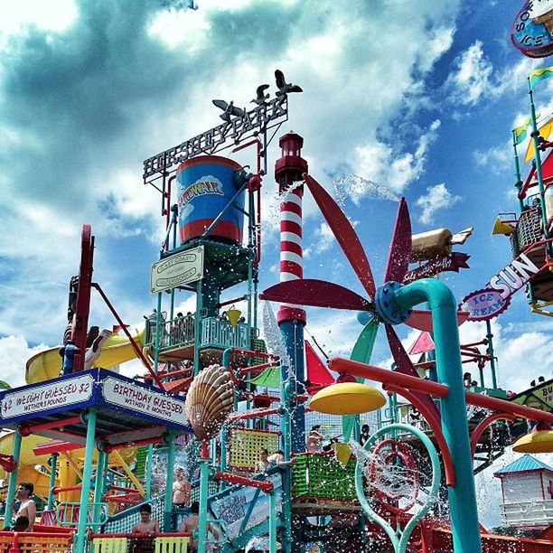 sky, cloud - sky, low angle view, built structure, cloud, architecture, cloudy, building exterior, art and craft, creativity, amusement park, art, outdoors, day, multi colored, railing, blue, arts culture and entertainment, metal, amusement park ride