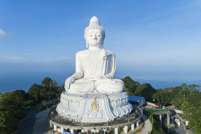 Statue of buddha against blue sky