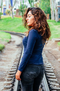 Side view of senior woman standing on railroad track