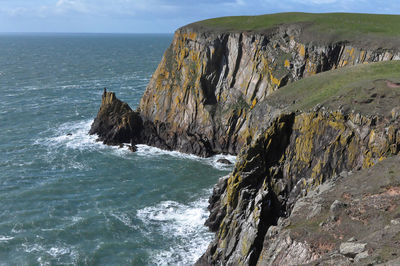 Rock formations by sea against sky