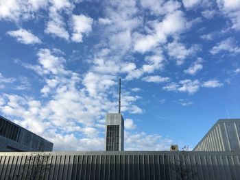 Low angle view of buildings against cloudy sky