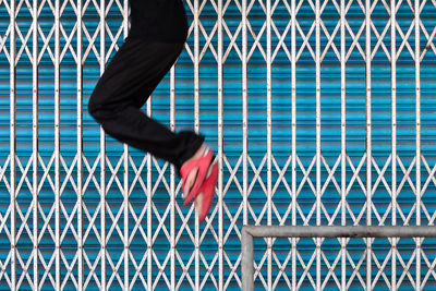 Low section of man against closed shutter