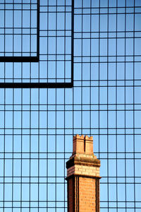 Old chimney in front of a facade of glass in birmingham, uk, shows the development of architecture