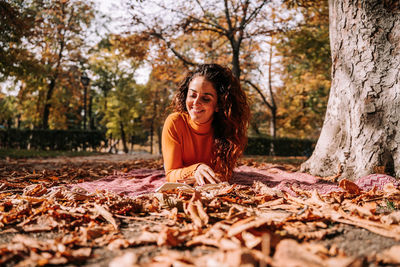 Portrait of a smiling young woman with autumn leaves