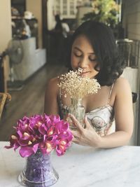 Midsection of woman holding flower on table