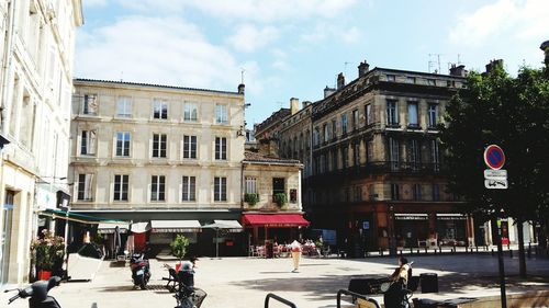 Buildings in city against cloudy sky