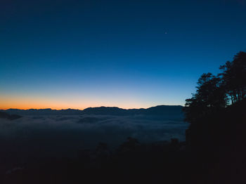 Scenic view of silhouette mountains against clear blue sky