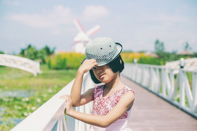 Young woman wearing hat standing against sky