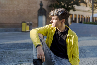 Portrait of a non binary person looking at camera while posing outdoors. person