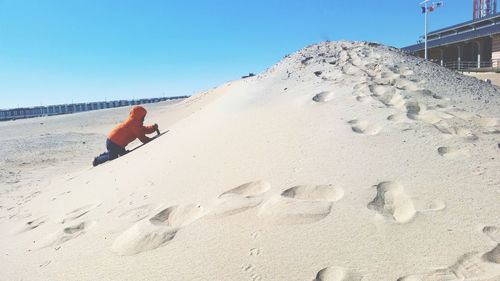 Man on beach against clear sky