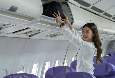 Young woman sitting on seat in airplane