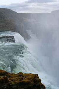 Scenic view of waterfall against sky