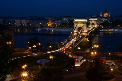 Illuminated light trails on chain bridge at night