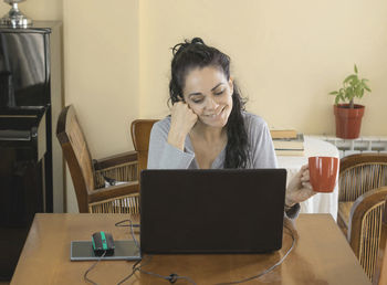 Mid adult man using smart phone while sitting on table