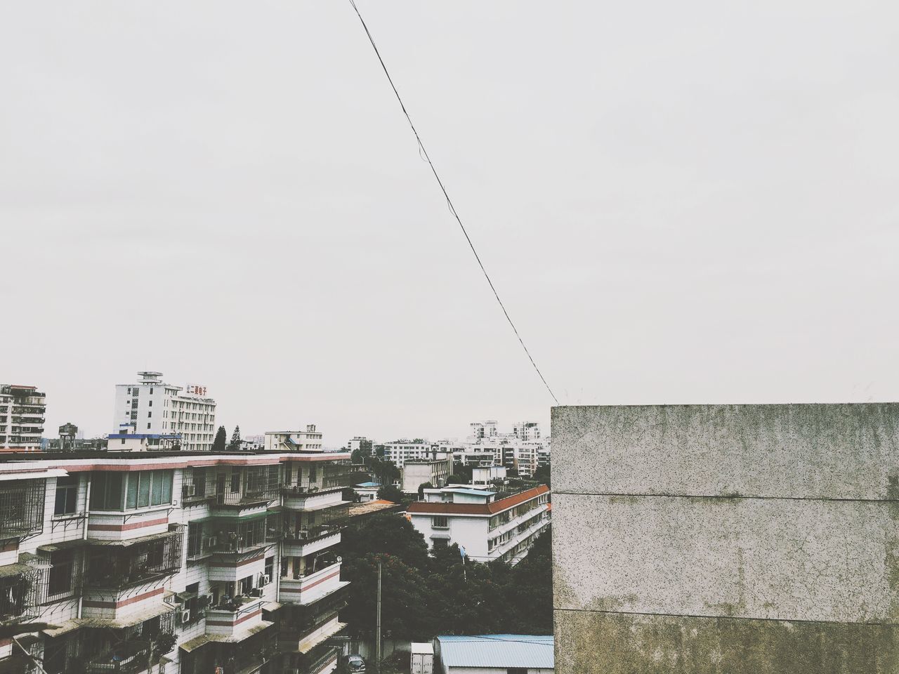 architecture, building exterior, built structure, clear sky, copy space, low angle view, city, construction site, residential structure, building, residential building, day, outdoors, development, sky, no people, house, construction, communication, wall - building feature