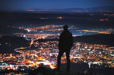 Silhouette of person standing in city at night