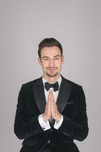Portrait of young man standing against white background