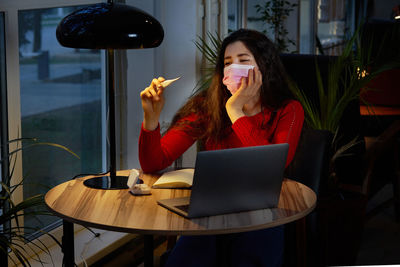 Sick woman taking temperature with thermometer