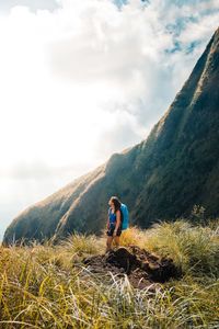 Woman standing on mountain against sky