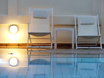 Empty chairs and tables in illuminated room