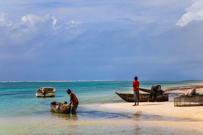 People on beach against sky