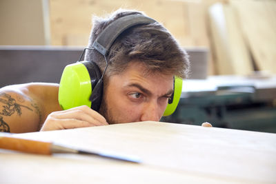 Craftsperson examining wooden plank in workshop