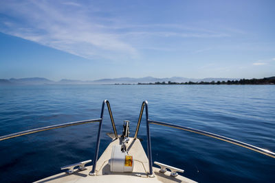 Boat sailing in sea against blue sky