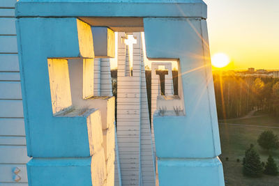 Text on wall by building against sky during sunset