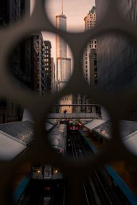 Railroad station seen through metal grate in city