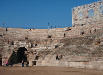 People walking in temple against clear sky