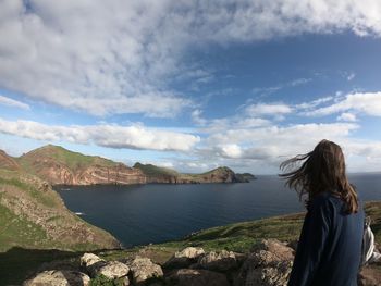 Woman looking at sea against sky