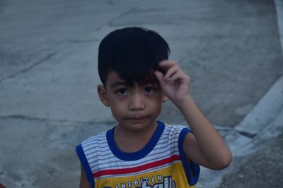 Close-up portrait of boy on footpath