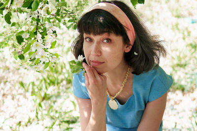 Portrait of beautiful woman against red flowering plants