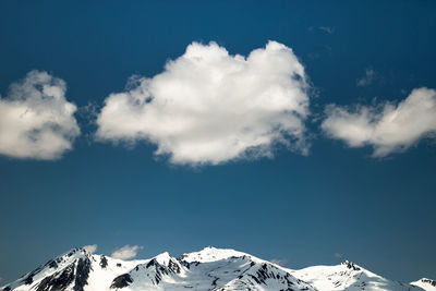 Low angle view of snowcapped mountains against sky