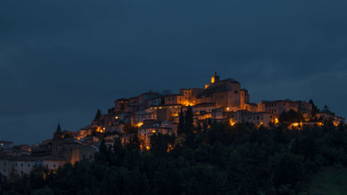 Illuminated buildings against sky at night