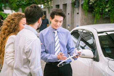 Friends standing by a car