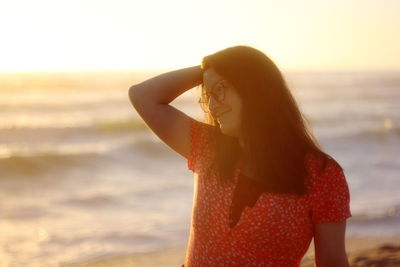 Rear view of woman standing at beach